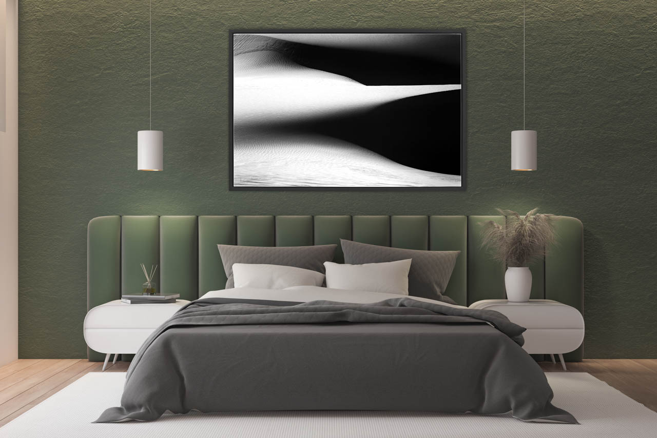 Tirage d'art en noir et blanc d'un paysage de dunes exposé dans une chambre parentale.