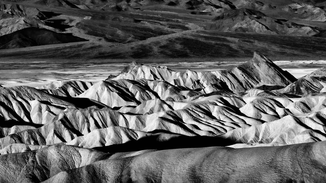 Photographie en noir et blanc de Zabriskie Point dans la vallée de la Mort aux Etats-Unis.