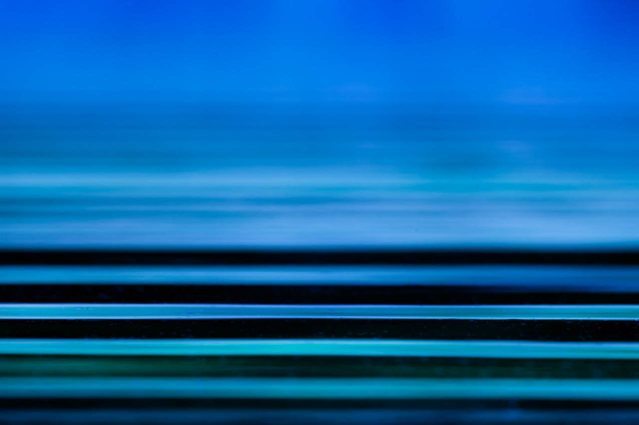 Photo abstraite de vaguelettes à la surface de l'eau. Les lignes horizontales donnent de la quiétude à la photo. Elles sont apaisantes.