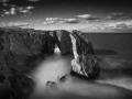 Seascape of Asturias in Spain in black and white.The waves of the Atlantic Oceans break on the rocks of the shore or on the cliffs.