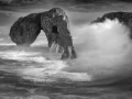 Seascape of Asturias in Spain in black and white.The waves of the Atlantic Oceans break on the rocks of the shore or on the cliffs.