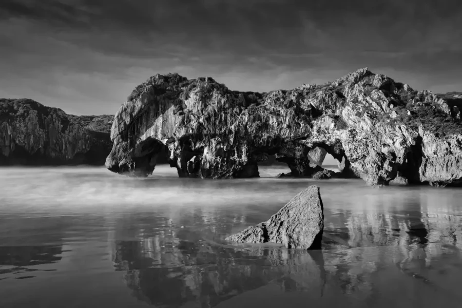 Seascape of Asturias in Spain in black and white.The waves of the Atlantic Oceans break on the rocks of the shore or on the cliffs.