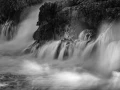 Seascape of Asturias in Spain in black and white.The waves of the Atlantic Oceans break on the rocks of the shore or on the cliffs.
