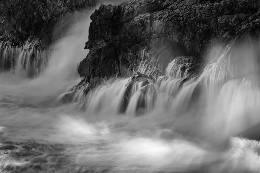 Seascape of Asturias in Spain in black and white.The waves of the Atlantic Oceans break on the rocks of the shore or on the cliffs.