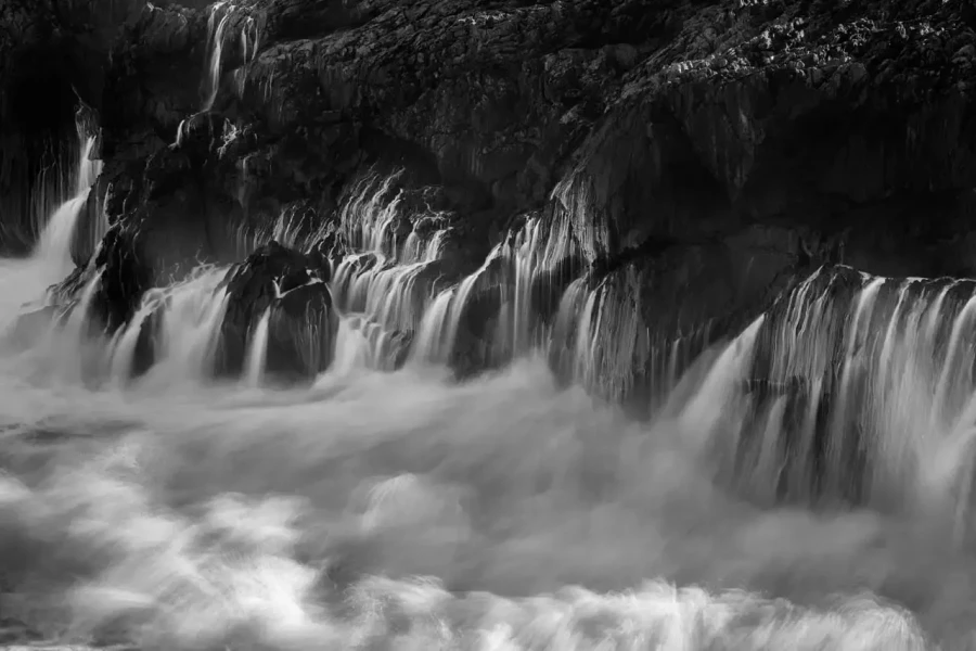 Seascape of Asturias in Spain in black and white.The waves of the Atlantic Oceans break on the rocks of the shore or on the cliffs.