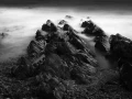 Seascape of Asturias in Spain in black and white.The waves of the Atlantic Oceans break on the rocks of the shore or on the cliffs.