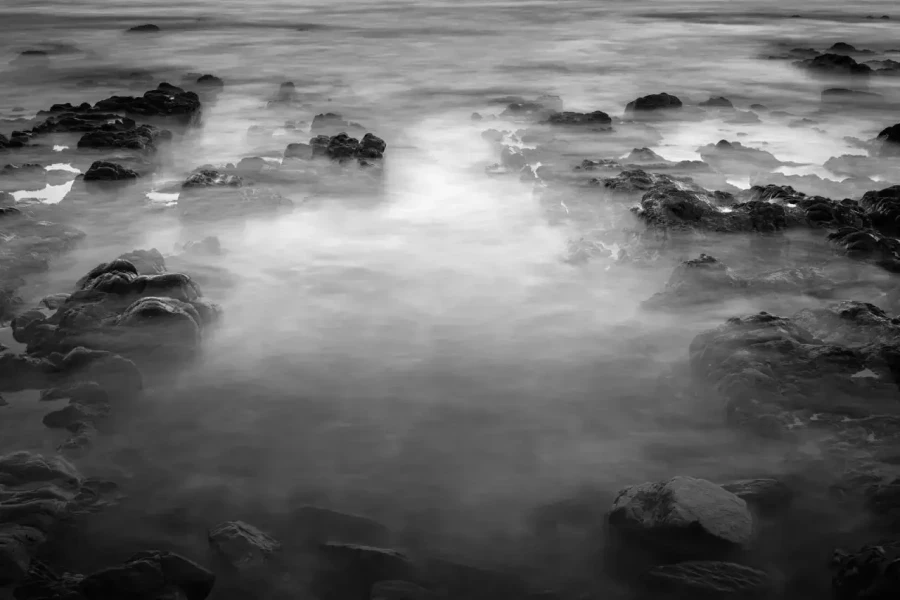 Seascape of Asturias in Spain in black and white.The waves of the Atlantic Oceans break on the rocks of the shore or on the cliffs.