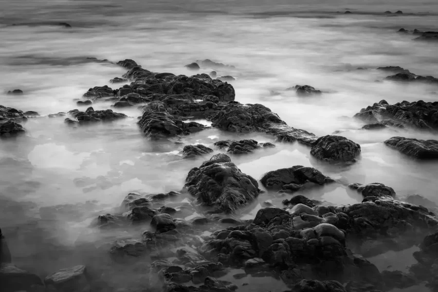 Seascape of Asturias in Spain in black and white.The waves of the Atlantic Oceans break on the rocks of the shore or on the cliffs.