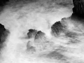 Seascape of Asturias in Spain in black and white.The waves of the Atlantic Oceans break on the rocks of the shore or on the cliffs.