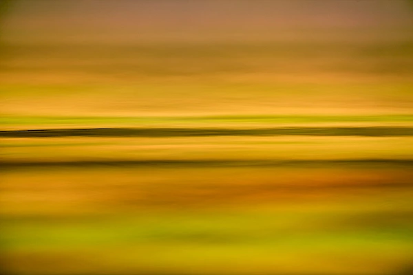 Les lignes horizontales à la surface de l'eau avec des tons chauds créent une photographie douce et apaisante.