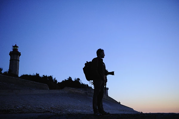 A photographer lost in thought contemplating a landscape in Charente-Maritime.