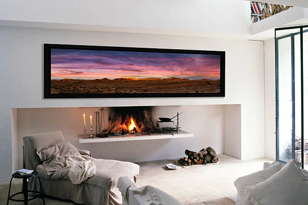 Une photo d'art en couleur de la collection 'Valley of Fire' accrochée au dessus d'une cheminée dans un salon.