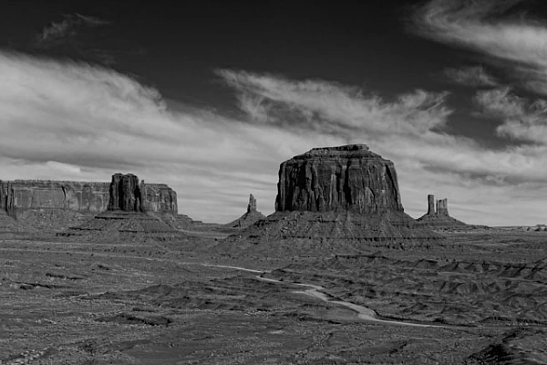 Photographie en noir et blanc d'un paysage minéral de Monument Valley dans l'Arizona aux Etats-Unis. Photographie par Amar Guillen, artiste photographe.