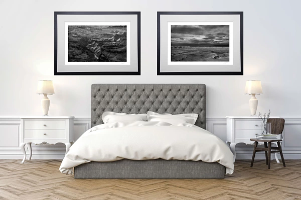 Deux photos d'art de paysages en noir et blanc en édition limitée accrochées sur un mur dans une chambre.