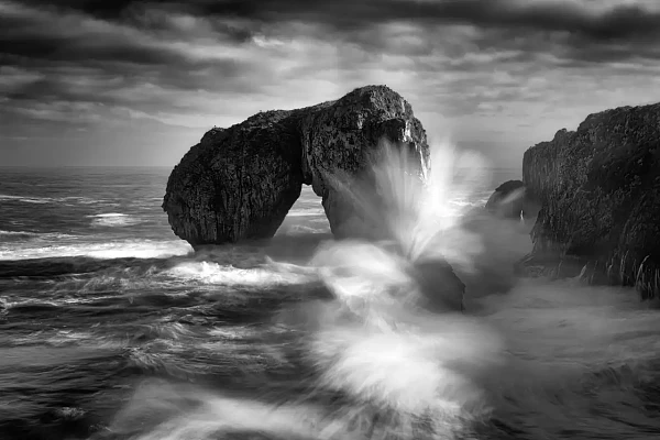 Waves of the Atlantic Ocean Breaking on rocks in Asturias Spain. El Castro de las Caviotas. Fine art Photograph in black and white by Amar Guillen, photographer artist.